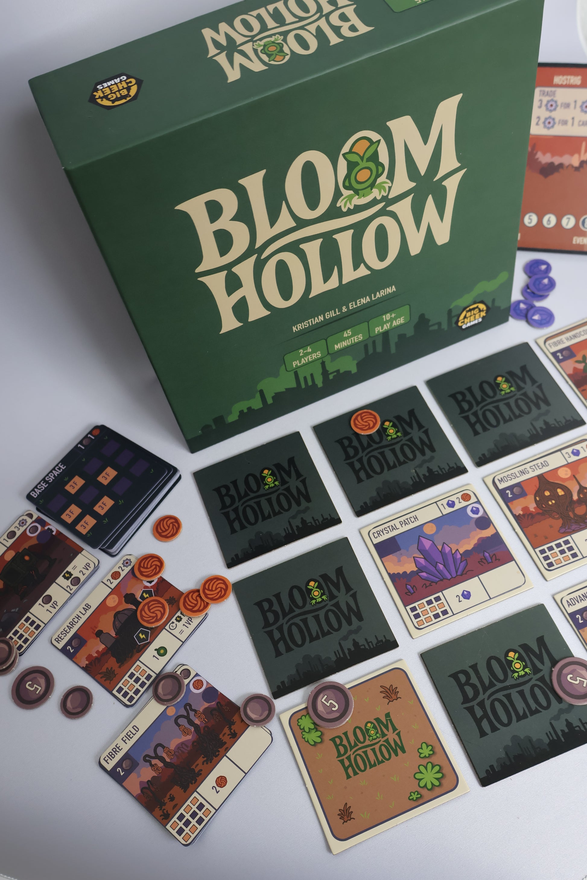 Board game 'Bloom Hollow' with cards and pieces on a white surface