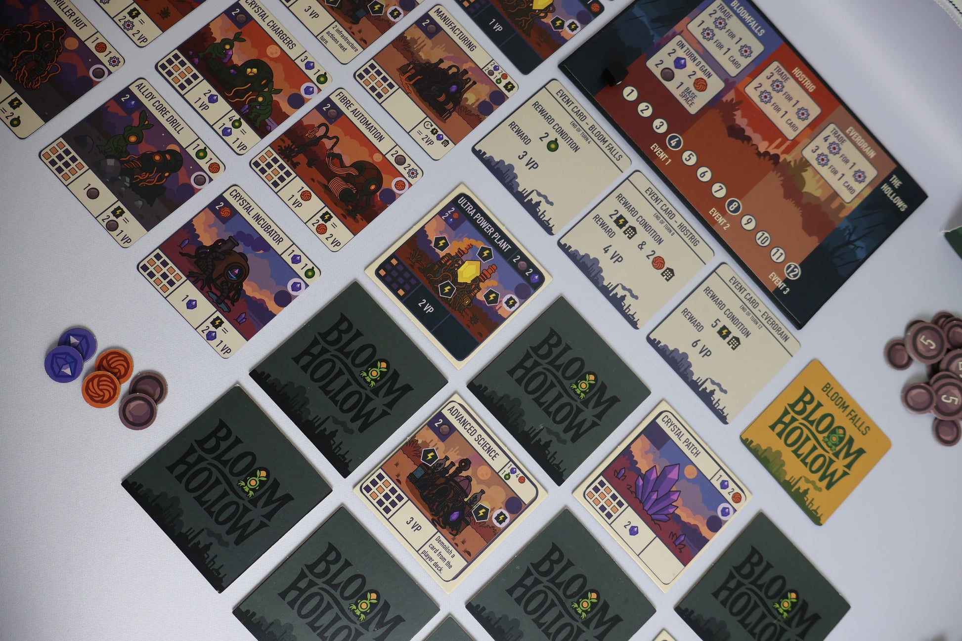 Collection of 'Bloom Hollow' game cards and pieces on a white surface