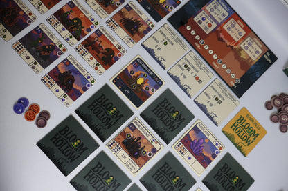 Collection of 'Bloom Hollow' game cards and pieces on a white surface